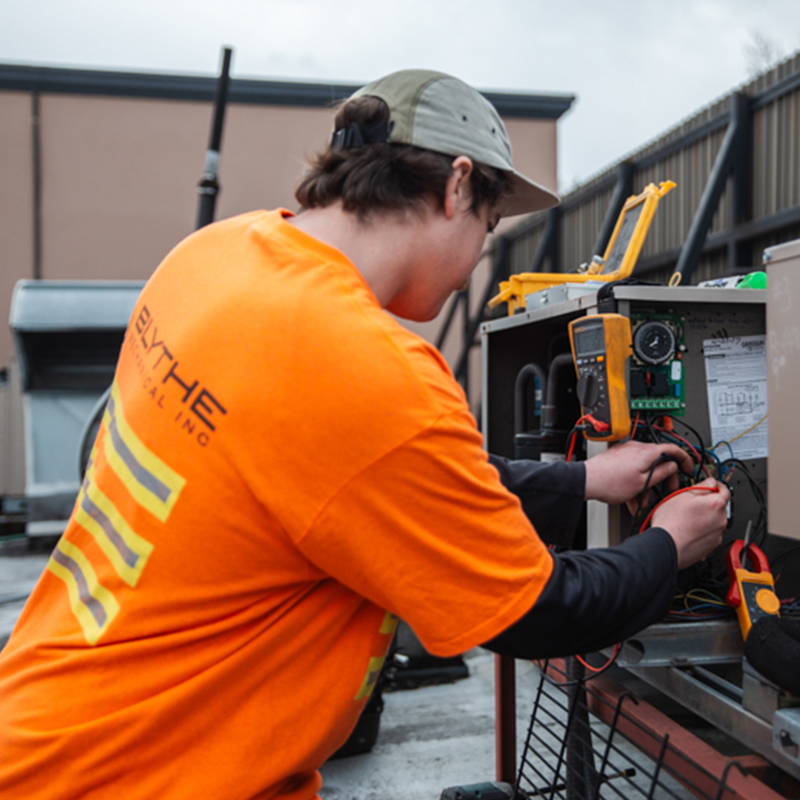 Blythe Mechanical technician performing preventative maintenance on commercial mechanical equipment at a customer facility.